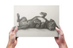 A pencil sketch print of a cane corso held up by human hands